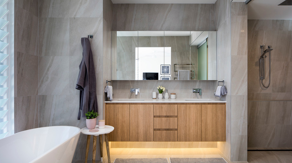 This is an example of a mid-sized beach style master bathroom in Sunshine Coast with furniture-like cabinets, medium wood cabinets, a freestanding tub, an open shower, white tile, porcelain tile, white walls, porcelain floors and engineered quartz benchtops.