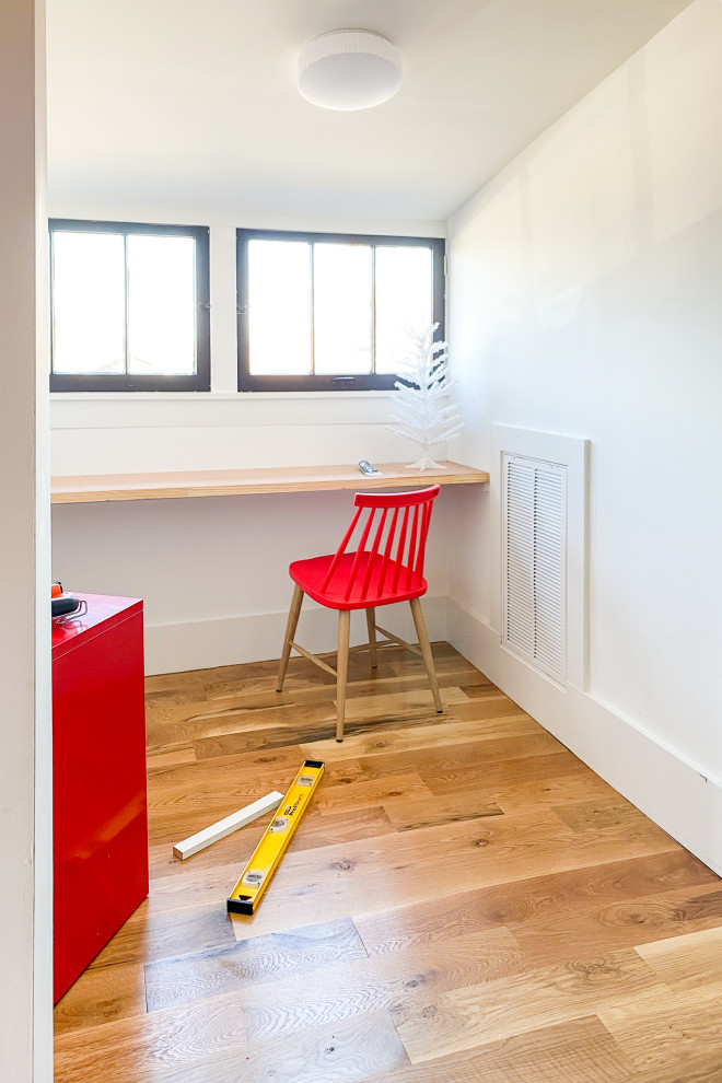 Inredning av ett modernt litet barnrum kombinerat med skrivbord och för 4-10-åringar, med vita väggar, ljust trägolv och brunt golv