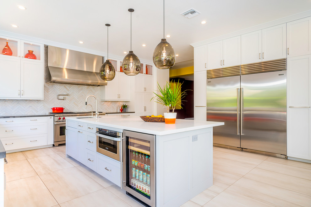 Photo of a mid-sized contemporary u-shaped eat-in kitchen in Los Angeles with a single-bowl sink, shaker cabinets, grey cabinets, quartz benchtops, white splashback, stainless steel appliances, porcelain floors, with island and beige floor.
