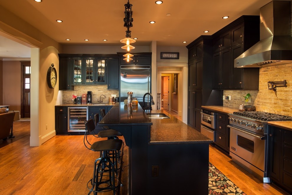 This is an example of a mid-sized transitional l-shaped open plan kitchen in DC Metro with an undermount sink, shaker cabinets, black cabinets, quartz benchtops, brown splashback, ceramic splashback, stainless steel appliances, medium hardwood floors and with island.