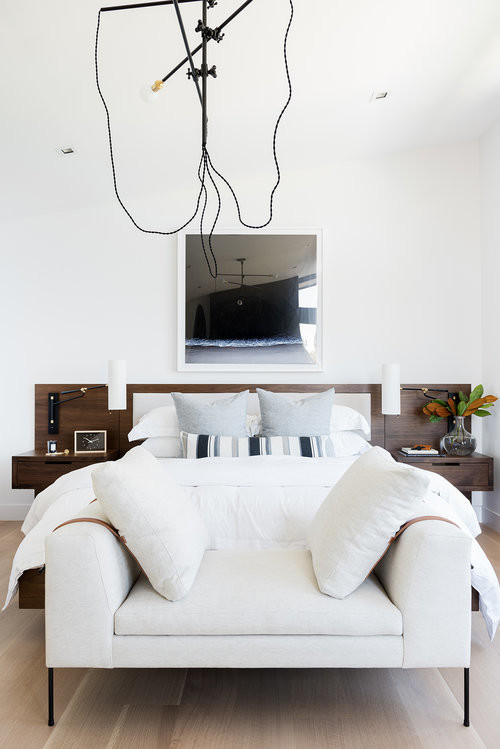 This is an example of a large modern master bedroom in Salt Lake City with white walls and light hardwood floors.
