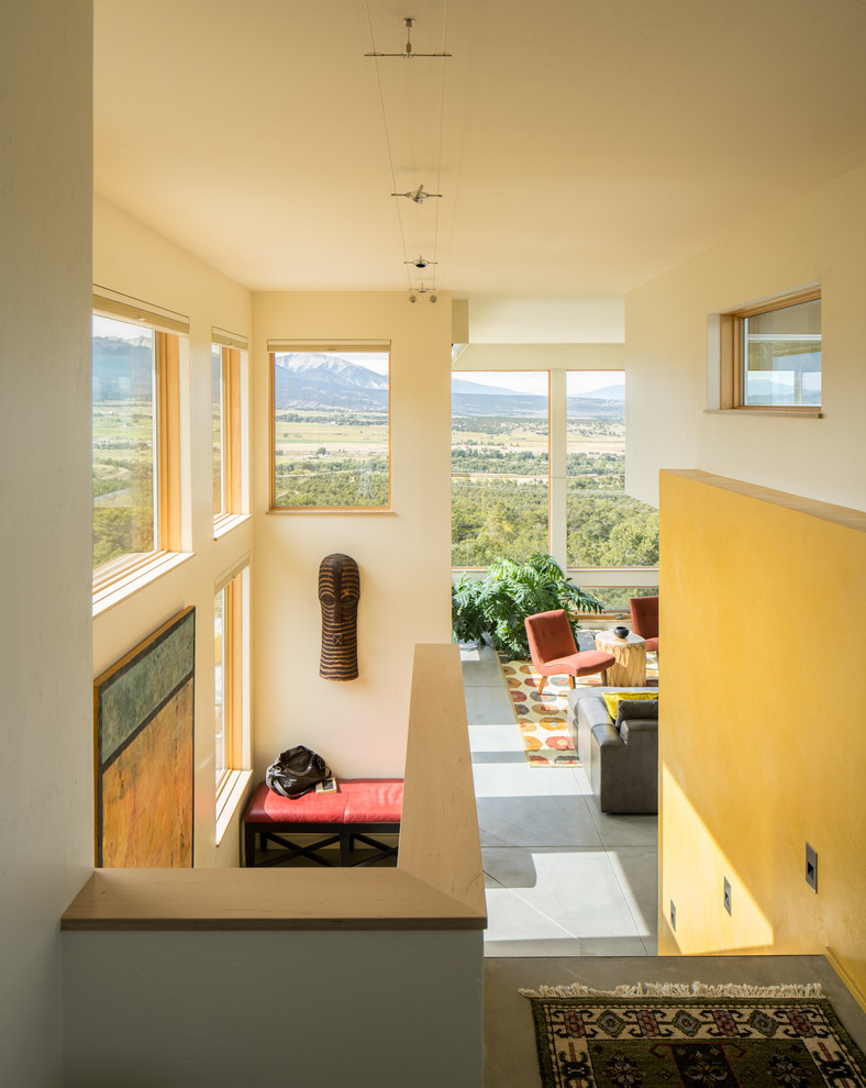 Example of a trendy concrete floor and gray floor hallway design in Denver with white walls