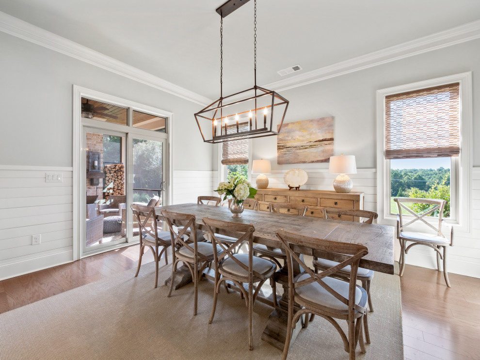 Inspiration for a country dining room in Atlanta with grey walls, medium hardwood floors and brown floor.