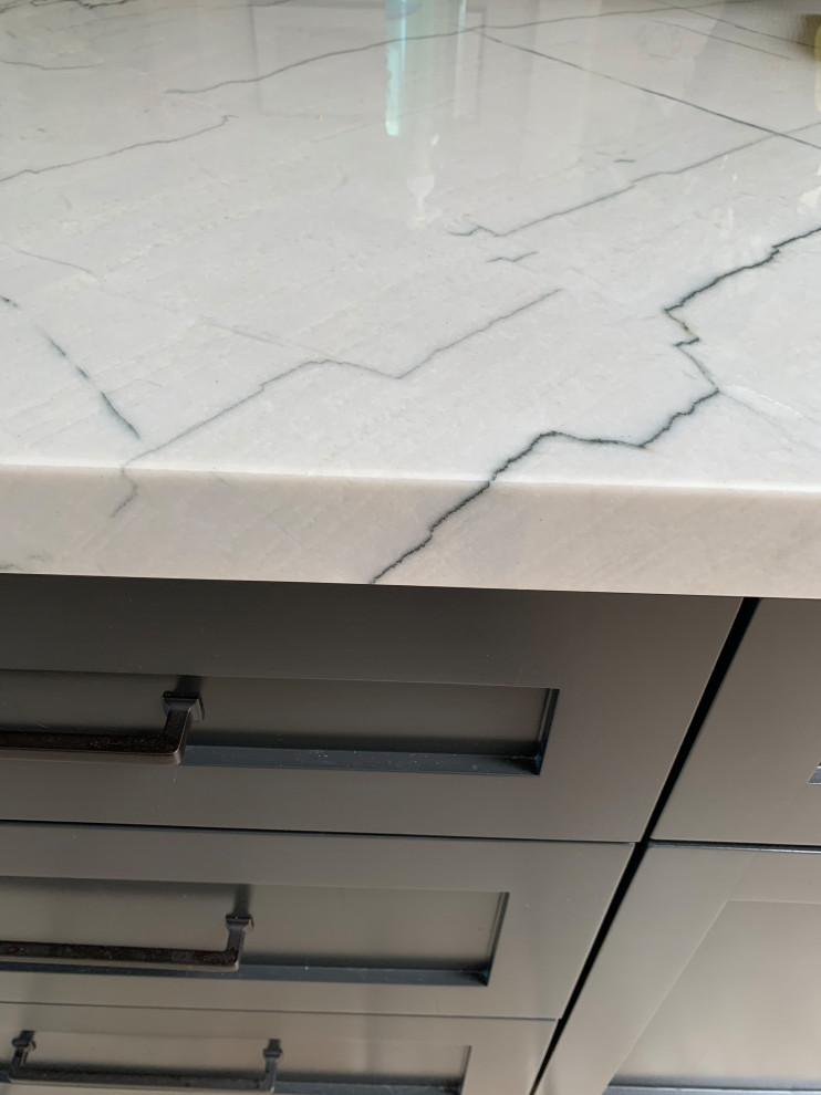 Inspiration for a large transitional travertine floor and beige floor kitchen remodel in Orange County with a single-bowl sink, shaker cabinets, white cabinets, quartzite countertops, white backsplash, ceramic backsplash, stainless steel appliances, an island and black countertops