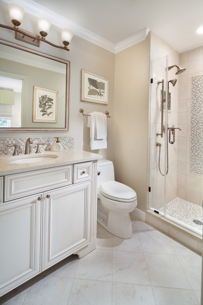 Inspiration for a mid-sized traditional 3/4 bathroom in DC Metro with beaded inset cabinets, white cabinets, an alcove shower, a one-piece toilet, beige tile, porcelain tile, beige walls, travertine floors, an undermount sink, beige floor and a hinged shower door.