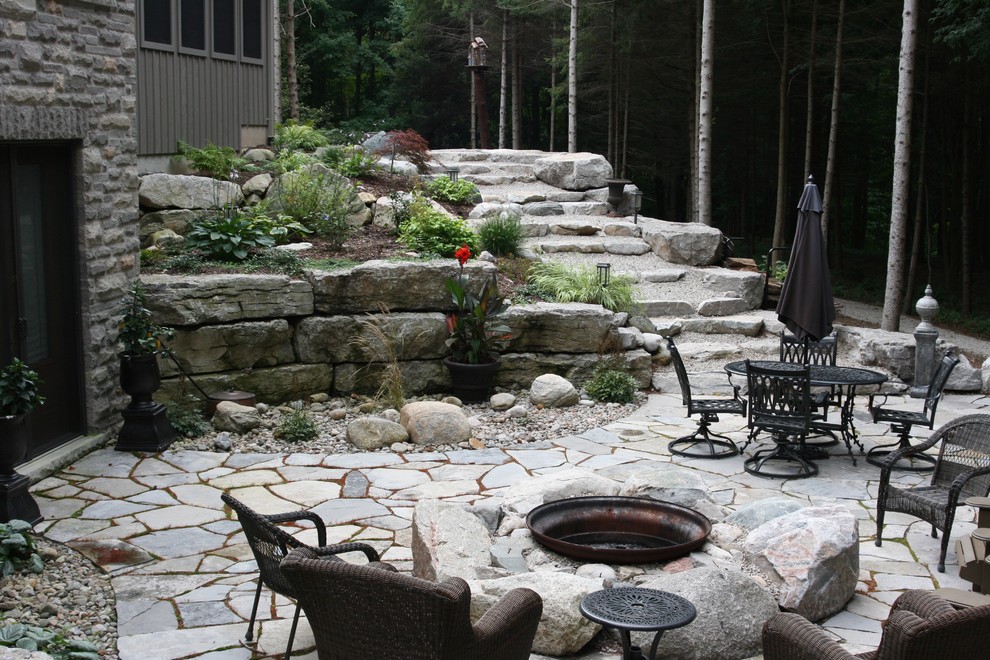 Inspiration for a mid-sized country backyard patio in Toronto with a fire feature and no cover.