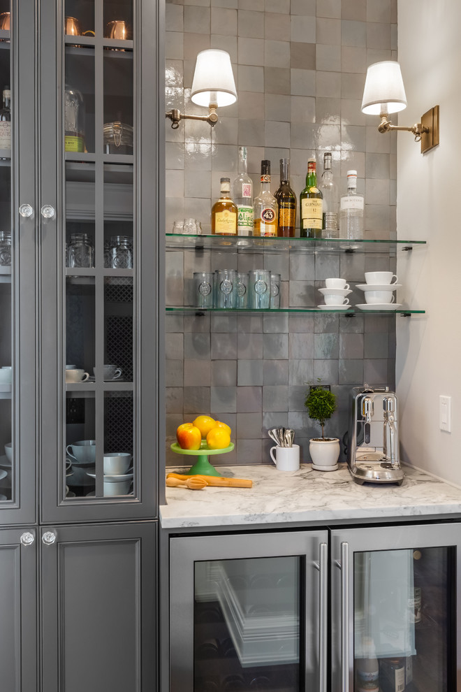 Design ideas for a small eclectic single-wall wet bar in Seattle with recessed-panel cabinets, grey cabinets, quartzite benchtops, grey splashback, terra-cotta splashback, medium hardwood floors, brown floor and white benchtop.