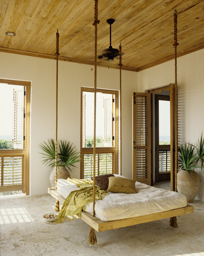 This is an example of a large tropical backyard screened-in verandah in Miami with tile.