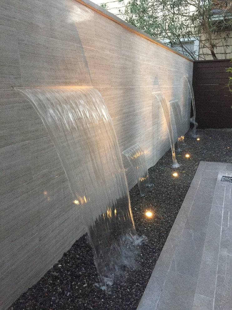 Inspiration for a small contemporary backyard patio in Jacksonville with a water feature, decomposed granite and no cover.