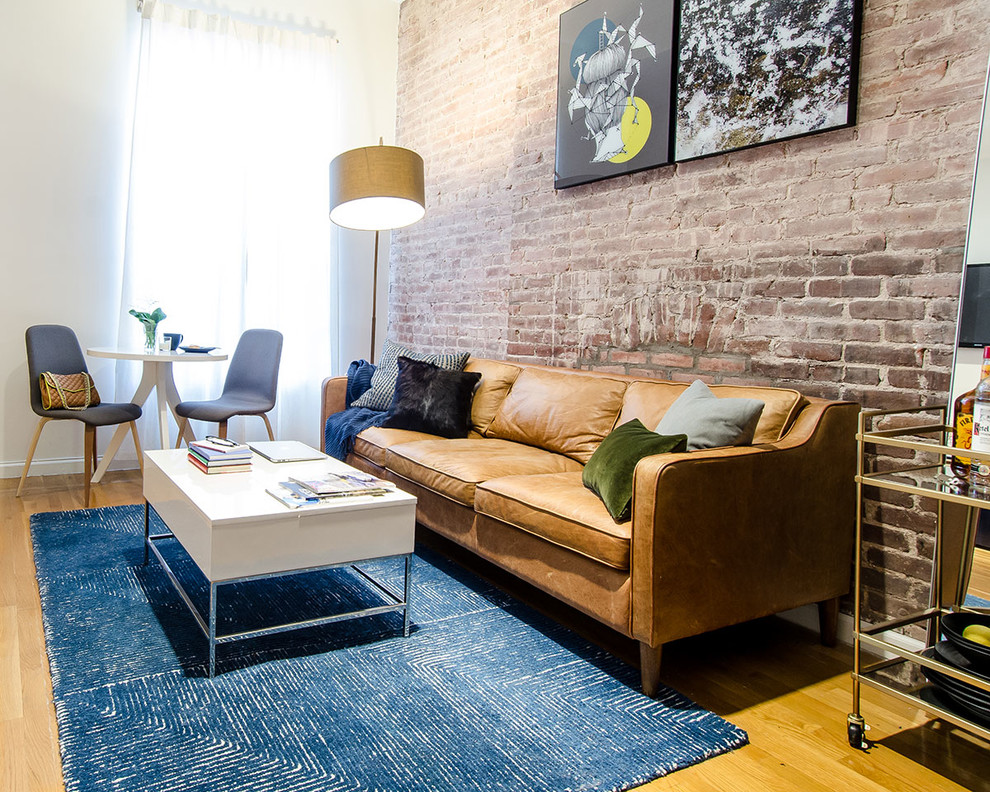 Example of a mid-sized trendy enclosed medium tone wood floor and beige floor living room design in New York with a bar, white walls, no fireplace and a wall-mounted tv