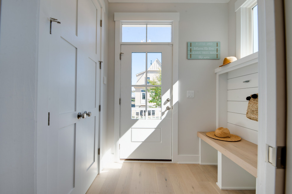 Photo of a small country mudroom in Other with grey walls, light hardwood floors, a single front door, a black front door, grey floor and planked wall panelling.