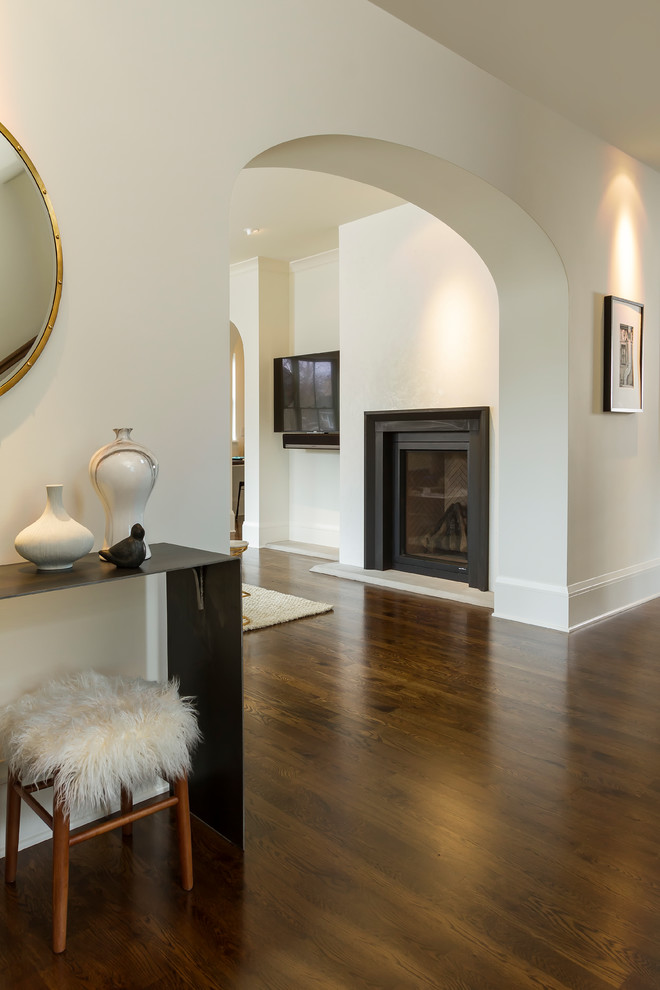 Photo of a large transitional foyer in Minneapolis with white walls, dark hardwood floors, a single front door, a dark wood front door and brown floor.