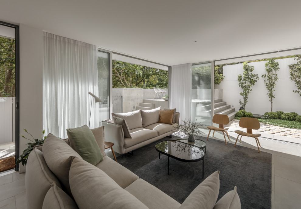 Пример оригинального дизайна: гостиная комната в стиле модернизм с белыми стенами и серым полом