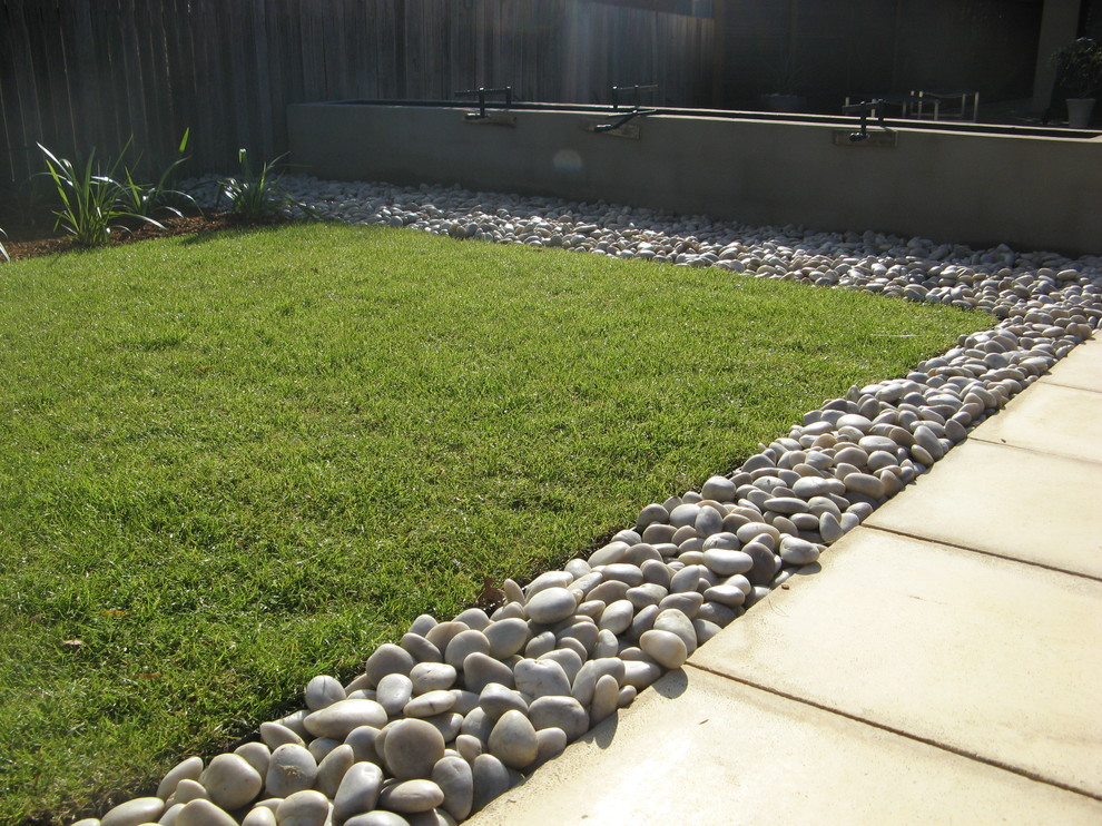 Design ideas for a small contemporary full sun xeriscape for spring in Canberra - Queanbeyan with a water feature and natural stone pavers.