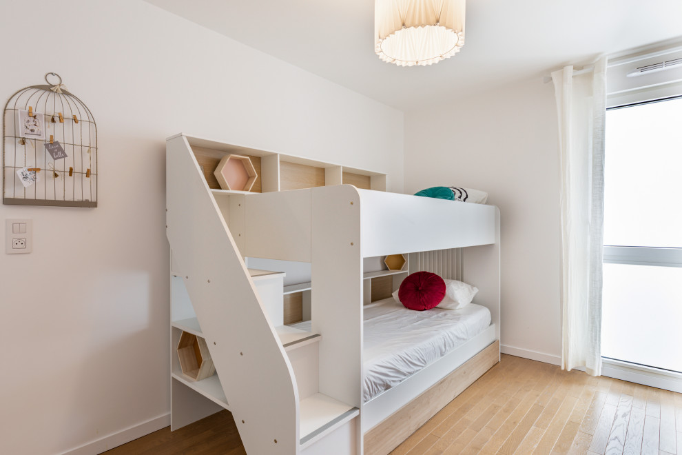 Design ideas for a contemporary kids' bedroom in Paris with multi-coloured walls and light hardwood flooring.