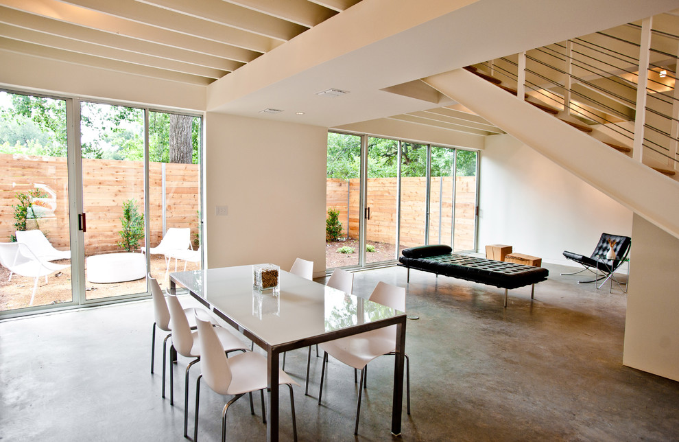 Photo of a modern dining room in Dallas with concrete floors.