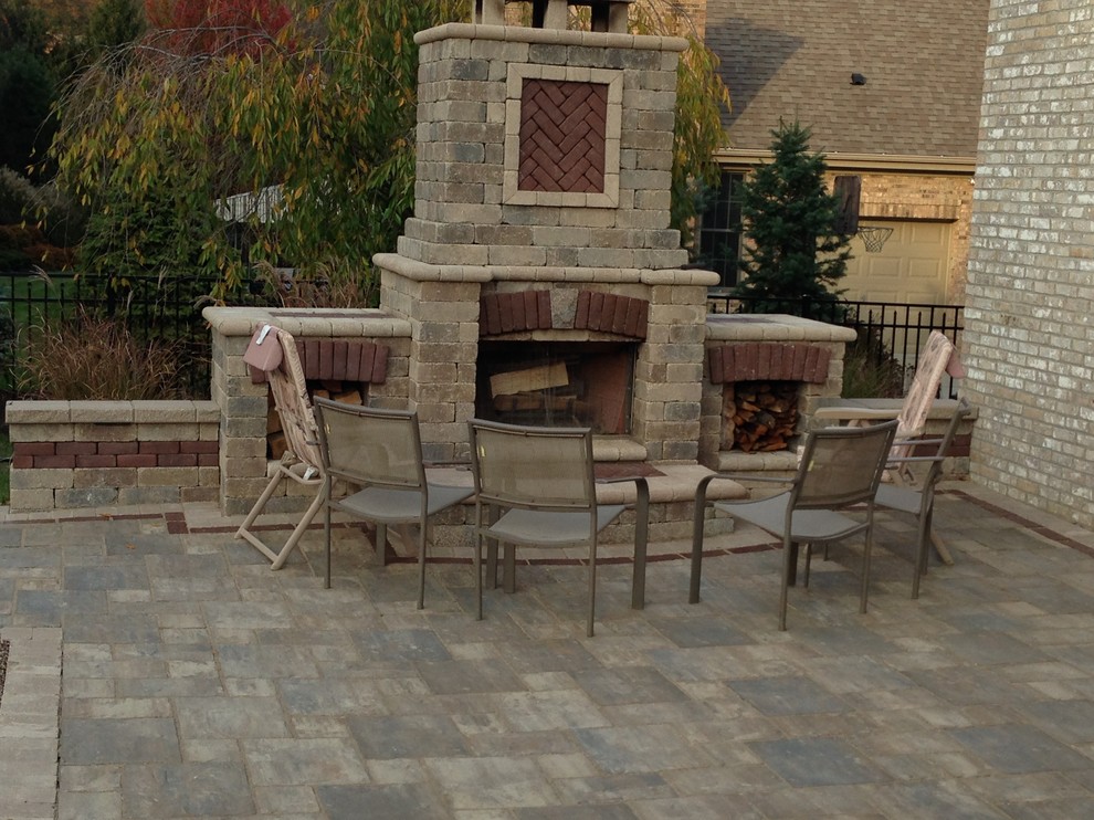 Mid-sized traditional backyard patio in Other with a fire feature, natural stone pavers and no cover.