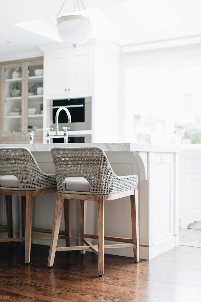 Mid-sized transitional dark wood floor and brown floor eat-in kitchen photo in Chicago with a farmhouse sink, beaded inset cabinets, white cabinets, quartz countertops, paneled appliances, an island and white countertops