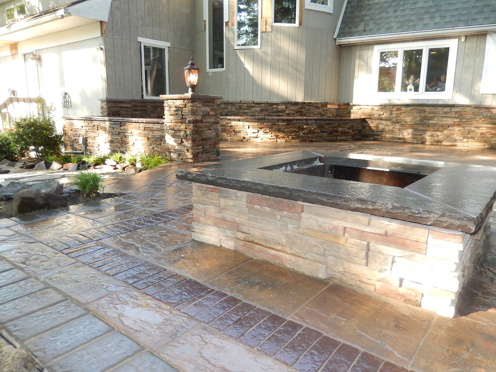 This is an example of a mid-sized contemporary backyard patio in Newark with a fire feature and concrete pavers.