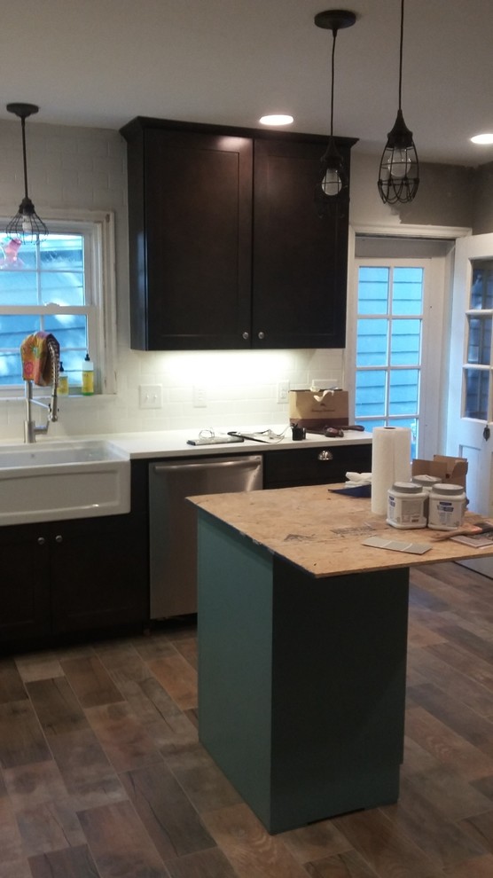 Inspiration for a mid-sized rustic u-shaped porcelain tile eat-in kitchen remodel in Indianapolis with a farmhouse sink, shaker cabinets, dark wood cabinets, wood countertops, white backsplash, ceramic backsplash, stainless steel appliances and an island