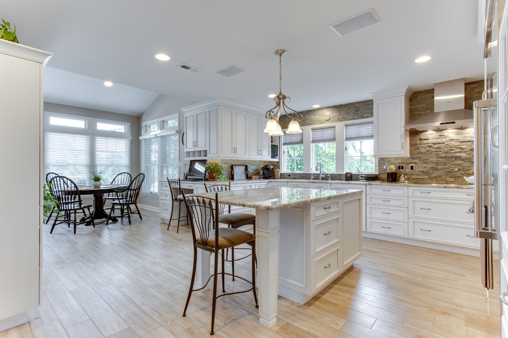 Inspiration for a large traditional u-shaped kitchen in DC Metro with an undermount sink, recessed-panel cabinets, granite benchtops, stone tile splashback, stainless steel appliances and multiple islands.
