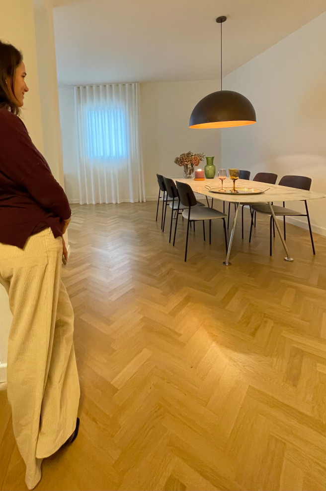 Foto di un'ampia sala da pranzo aperta verso il soggiorno con pareti beige e pavimento in legno massello medio