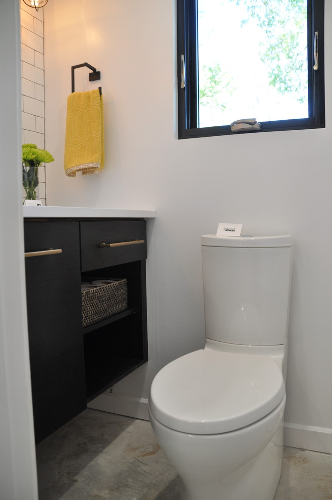 Источник вдохновения для домашнего уюта: туалет среднего размера в современном стиле с плоскими фасадами, черными фасадами, унитазом-моноблоком, белой плиткой, плиткой кабанчик, белыми стенами и врезной раковиной