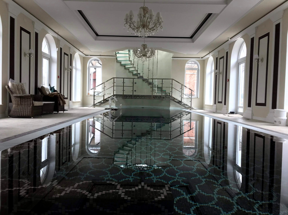 Винтовая стеклянная лестница над бассейном