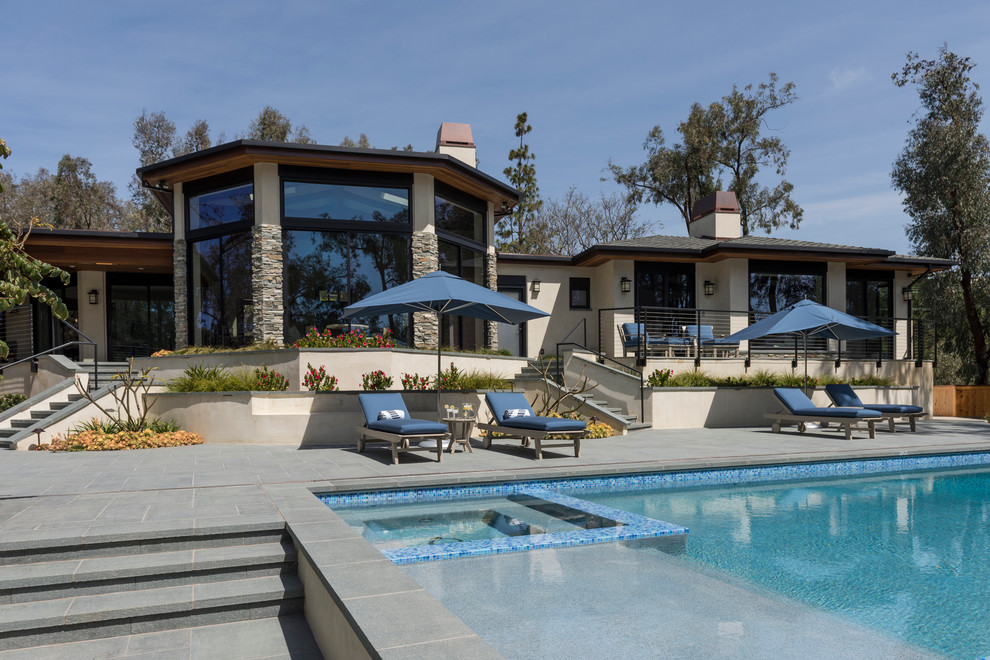 Inspiration for an expansive modern backyard rectangular lap pool in San Diego with a hot tub and tile.