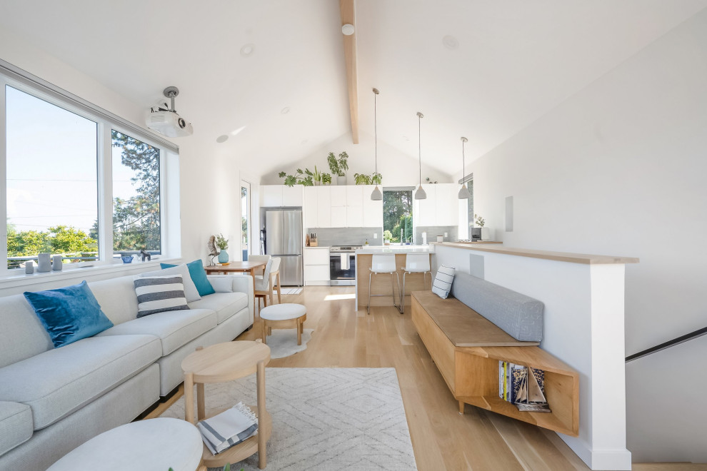 Inspiration for a small contemporary open concept light wood floor, brown floor and vaulted ceiling living room remodel in Portland with white walls