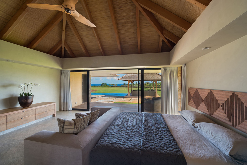 This is an example of a tropical guest bedroom in Hawaii with grey walls, limestone floors and grey floor.