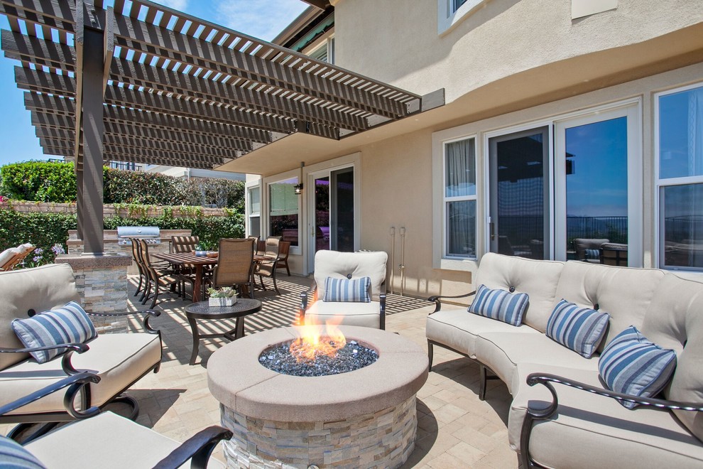 Design ideas for a small beach style backyard patio in Orange County with a fire feature.