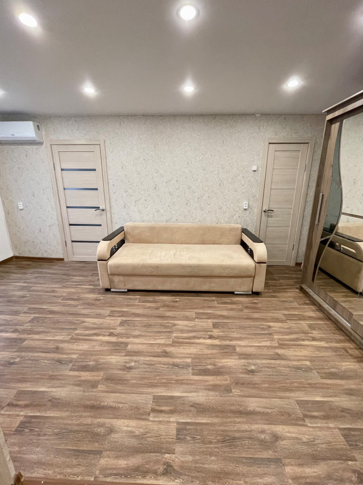 Immagine di un soggiorno minimal con pareti beige, pavimento in linoleum, nessuna TV e carta da parati
