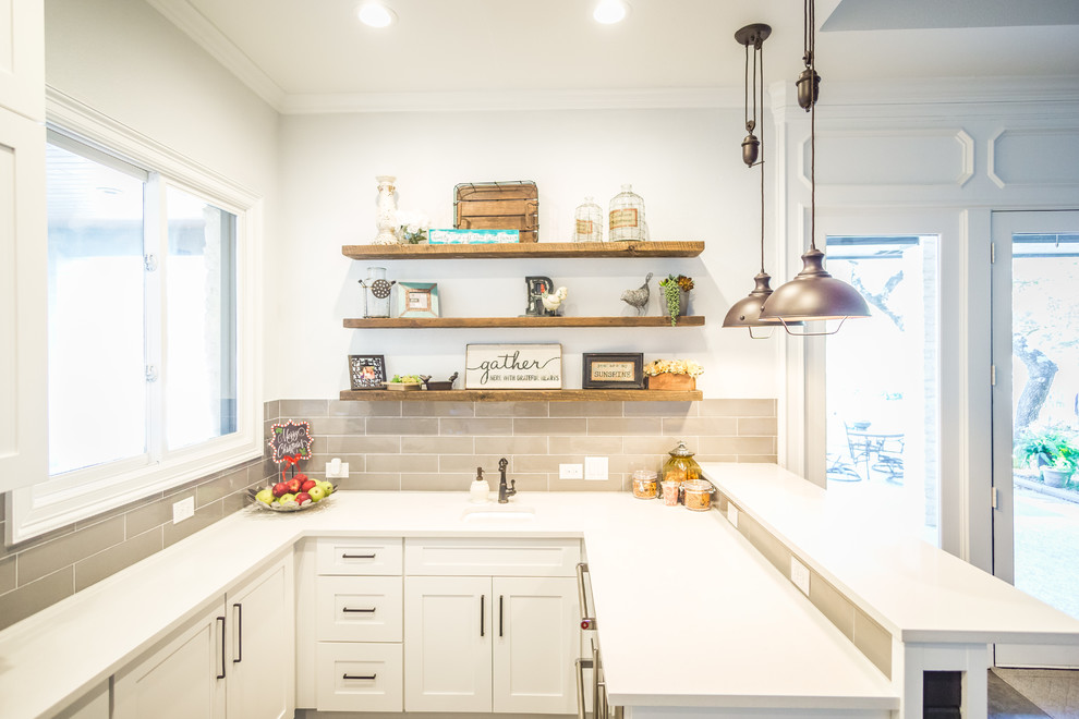 Design ideas for a large country galley eat-in kitchen in Austin with a farmhouse sink, shaker cabinets, white cabinets, granite benchtops, grey splashback, glass tile splashback, stainless steel appliances, cement tiles, multiple islands and grey floor.