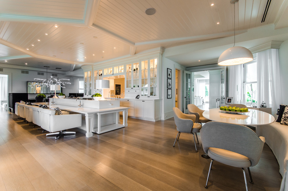 Design ideas for an expansive tropical galley kitchen in Miami with glass-front cabinets, white cabinets, quartz benchtops, panelled appliances and light hardwood floors.