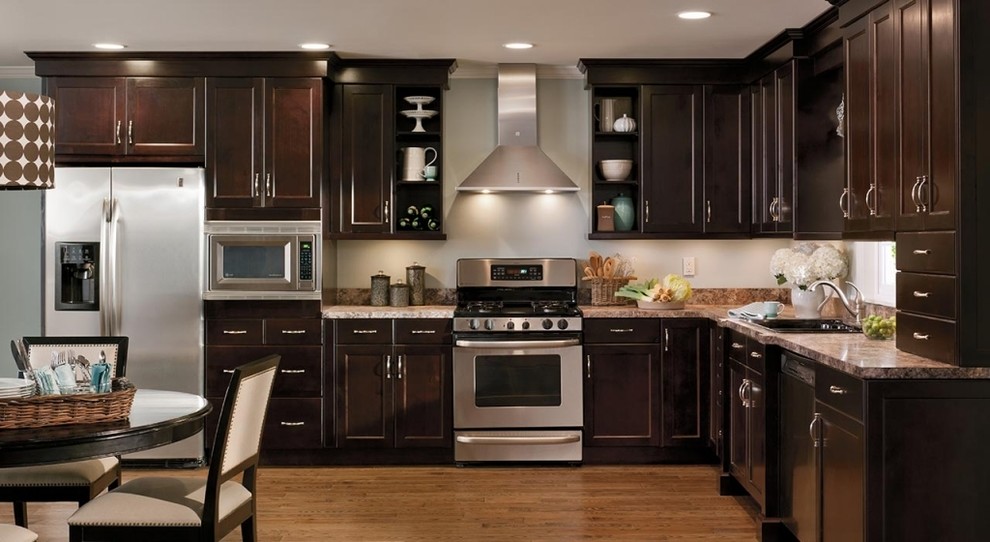 Kitchen - mid-sized transitional l-shaped medium tone wood floor kitchen idea in Chicago with a drop-in sink, shaker cabinets, dark wood cabinets, granite countertops, white backsplash and stainless steel appliances