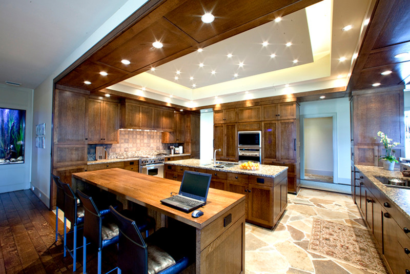 Inspiration for a large transitional u-shaped slate floor and beige floor enclosed kitchen remodel in Orange County with an undermount sink, shaker cabinets, medium tone wood cabinets, granite countertops, beige backsplash, stone tile backsplash, stainless steel appliances and an island