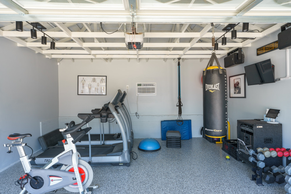 Example of a mid-sized minimalist concrete floor, multicolored floor and exposed beam home gym design in Los Angeles with gray walls