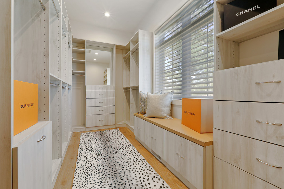Built-in closet - large transitional women's light wood floor and brown floor built-in closet idea with flat-panel cabinets and brown cabinets