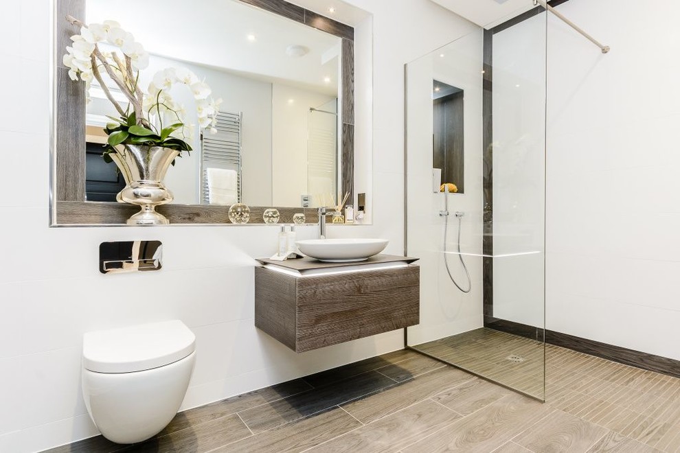 Inspiration for a mid-sized contemporary 3/4 bathroom in London with medium wood cabinets, an open shower, a wall-mount toilet, brown tile, ceramic tile, beige walls, ceramic floors, a vessel sink and an open shower.