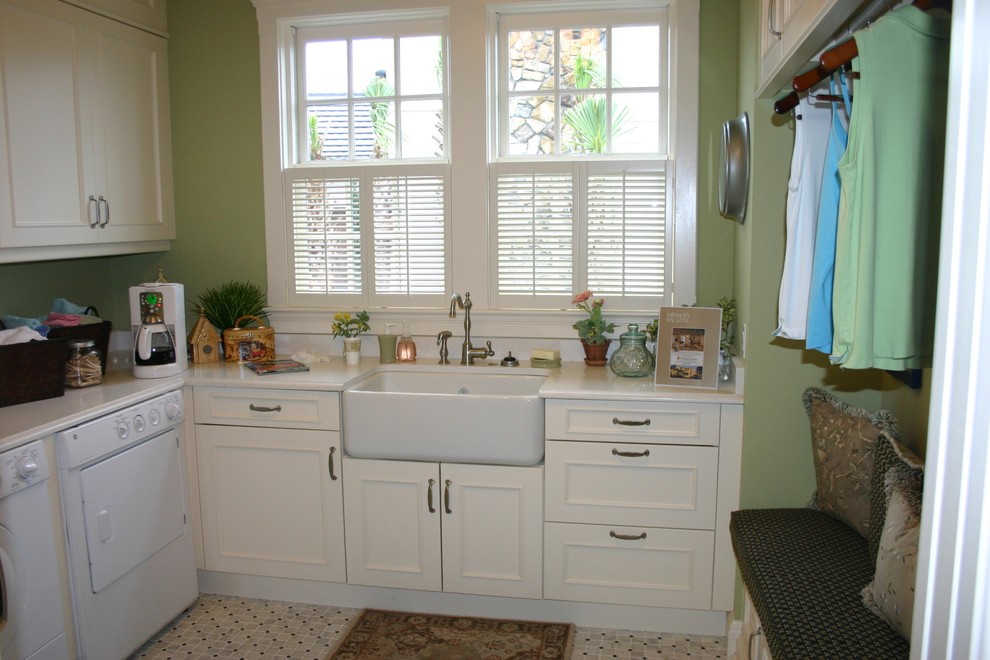 Mid-sized country u-shaped dedicated laundry room in Tampa with a farmhouse sink, recessed-panel cabinets, white cabinets, quartz benchtops, green walls, ceramic floors and a side-by-side washer and dryer.