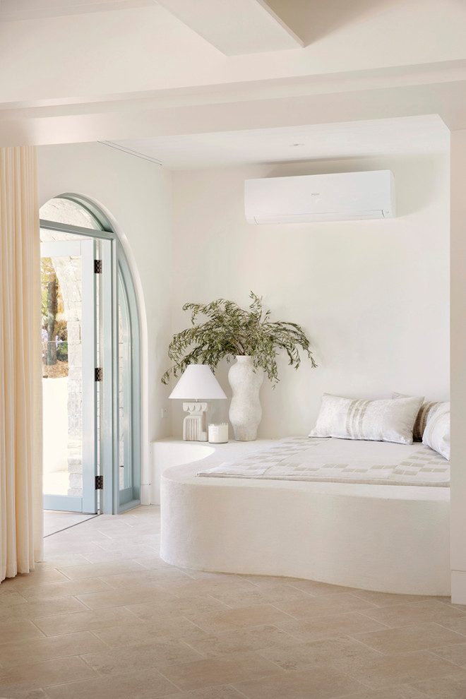 Esempio di una camera da letto mediterranea con pareti bianche, pavimento in gres porcellanato e pavimento beige