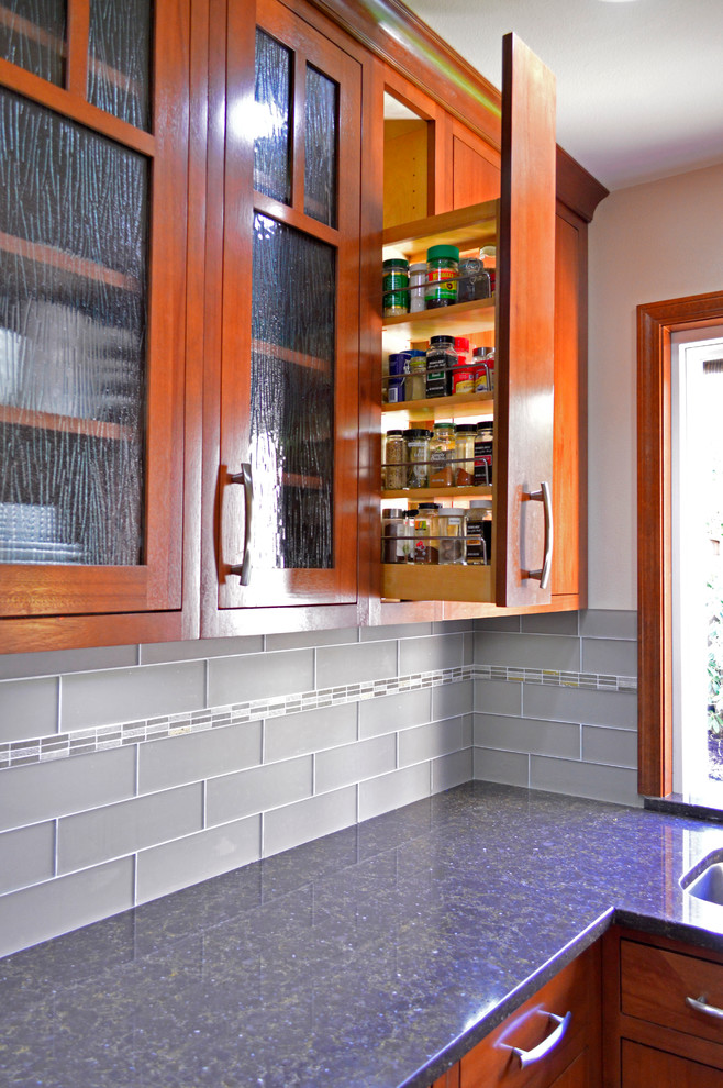 Large transitional medium tone wood floor open concept kitchen photo in Seattle with an undermount sink, flat-panel cabinets, dark wood cabinets, quartz countertops, gray backsplash, subway tile backsplash, stainless steel appliances and an island
