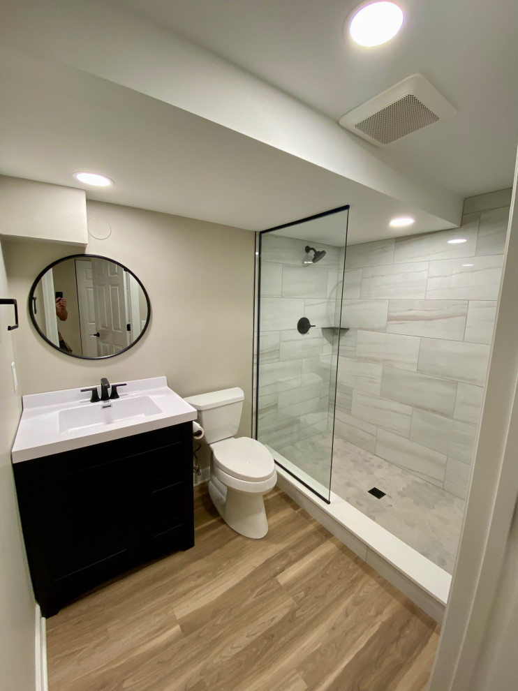 Small minimalist 3/4 gray tile and ceramic tile laminate floor, brown floor and single-sink bathroom photo in Chicago with shaker cabinets, black cabinets, a two-piece toilet, beige walls, an integrated sink, quartz countertops, white countertops and a built-in vanity