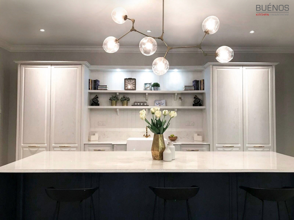 Example of a large transitional l-shaped ceramic tile and beige floor eat-in kitchen design with a farmhouse sink, beaded inset cabinets, blue cabinets, quartzite countertops, beige backsplash, quartz backsplash, stainless steel appliances, an island and beige countertops
