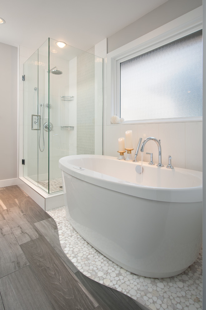 Photo of a transitional master bathroom in Vancouver with an undermount sink, a freestanding tub, a corner shower, a one-piece toilet, gray tile, mosaic tile and grey walls.