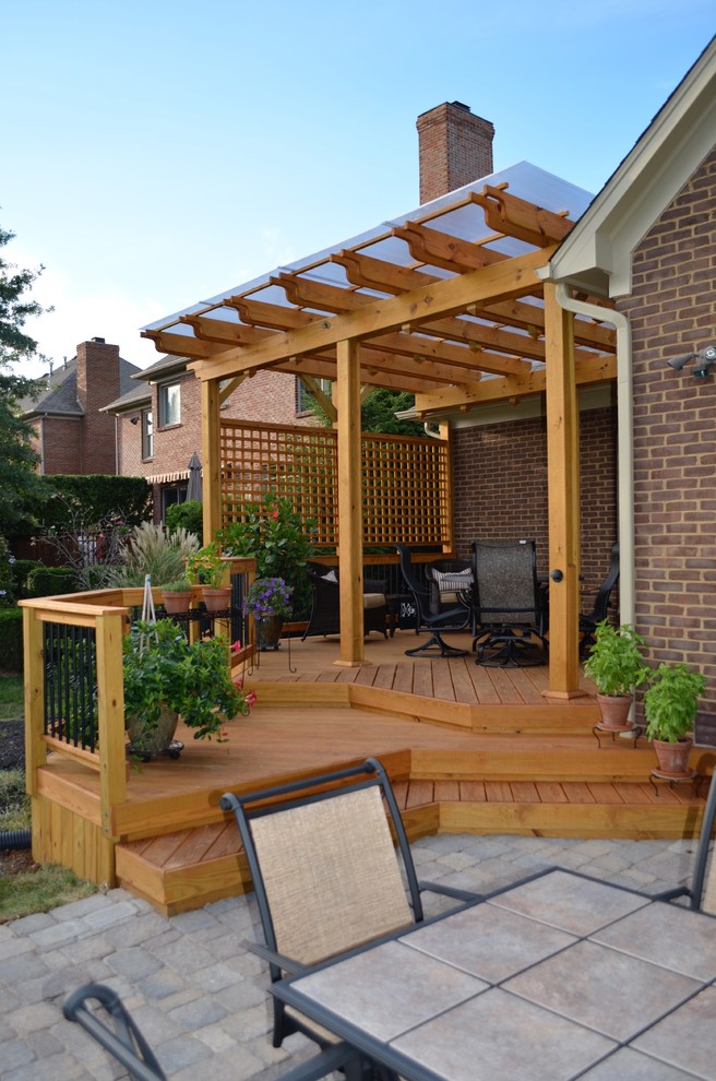 Inspiration for a mid-sized traditional backyard deck in Other with a pergola.