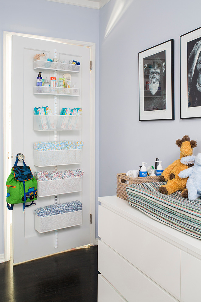 Inspiration for a transitional boy dark wood floor nursery remodel with blue walls