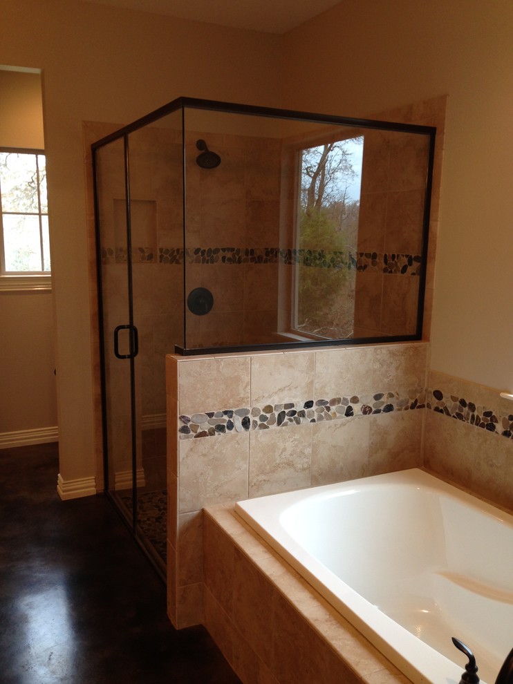 This is an example of a large transitional master bathroom in Dallas with a drop-in sink, a drop-in tub, a corner shower, beige walls, concrete floors, multi-coloured tile and pebble tile.