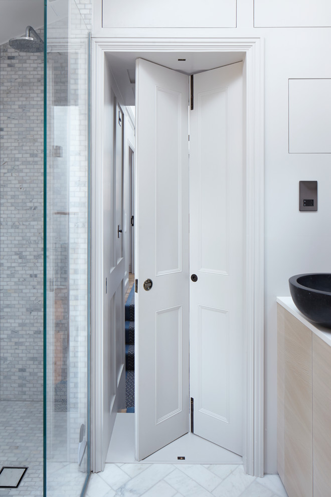 Inspiration for a small contemporary bathroom in London with flat-panel cabinets, light wood cabinets, a drop-in tub, an open shower, a one-piece toilet, gray tile, ceramic tile, white walls, mosaic tile floors, a console sink and engineered quartz benchtops.
